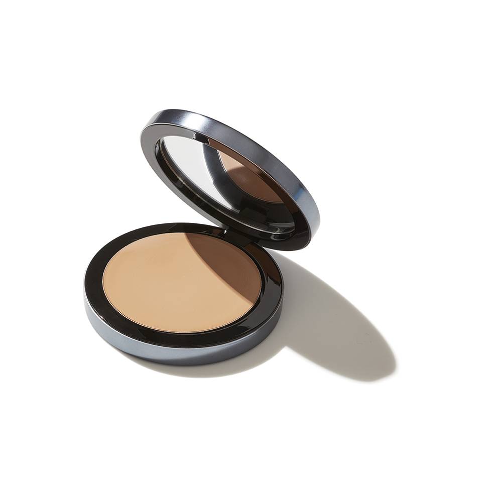 A compact powder makeup in an open circular container with a mirror on the inside of the lid, isolated on a white background, casting a soft shadow.