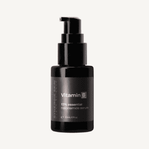 A bottle of "synergie skin" vitamin b niacinamide serum with a black pump dispenser, labeled clearly in white text. the container holds 30ml/1oz of the product.