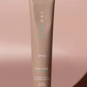 A taupe tube labeled "Pearl Glow SPF50+ Dreamscreen 75ml" stands upright on a matching background. Text highlights its illuminating, hydrating formula as a broad spectrum UVA + UVB sunscreen.